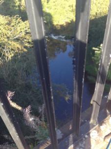 LOOKING DOWN TO RIVER THROUGH RAILINGS
